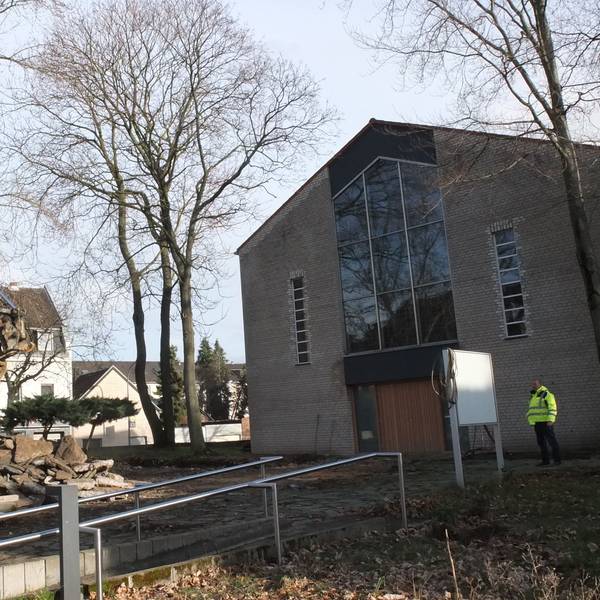 Ein Bagger steht vor einer Kirche.