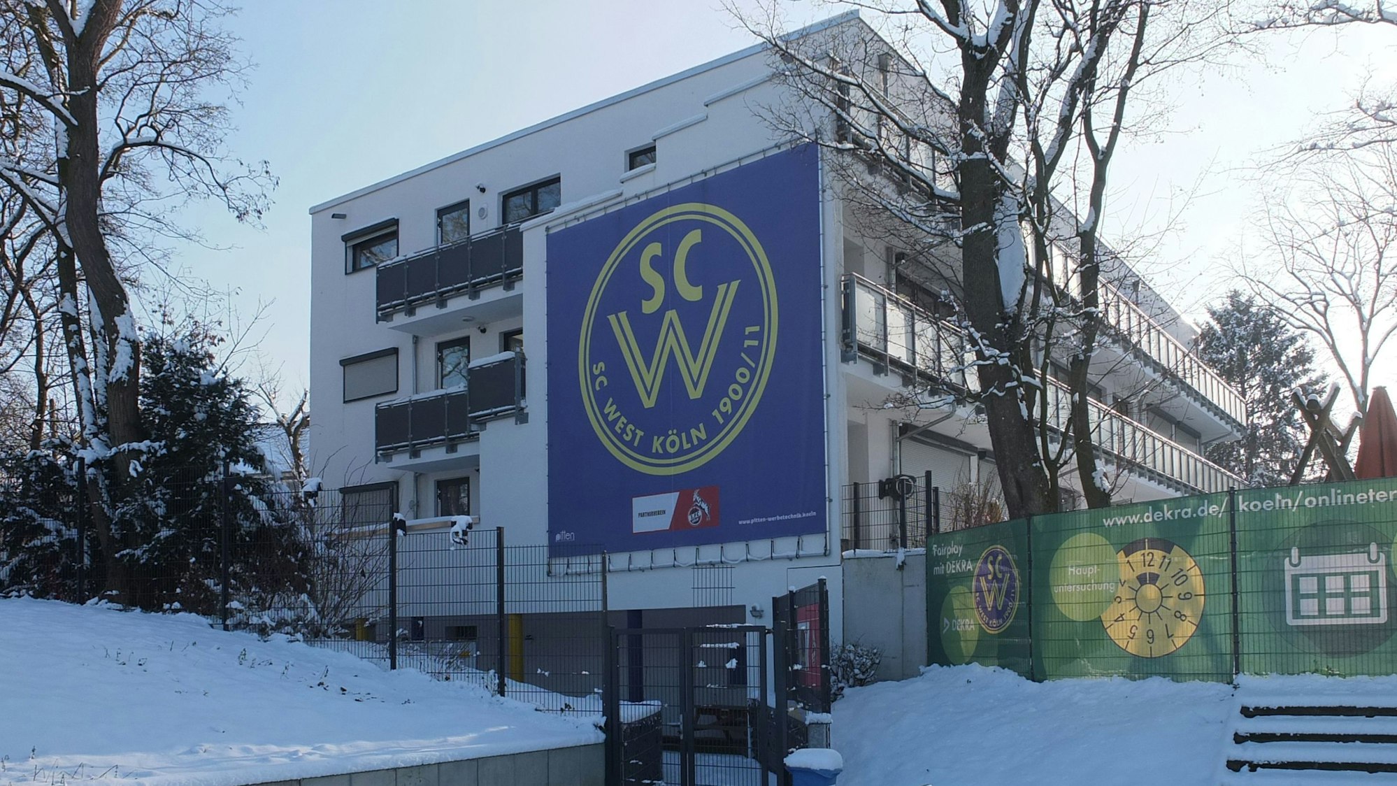 Blick auf ein dreistöckiges Gebäude mit dem Banner des SC West.