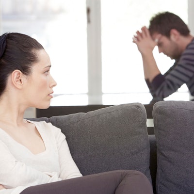 Frau und Mann sitzen zerstritten im Wohnzimmer