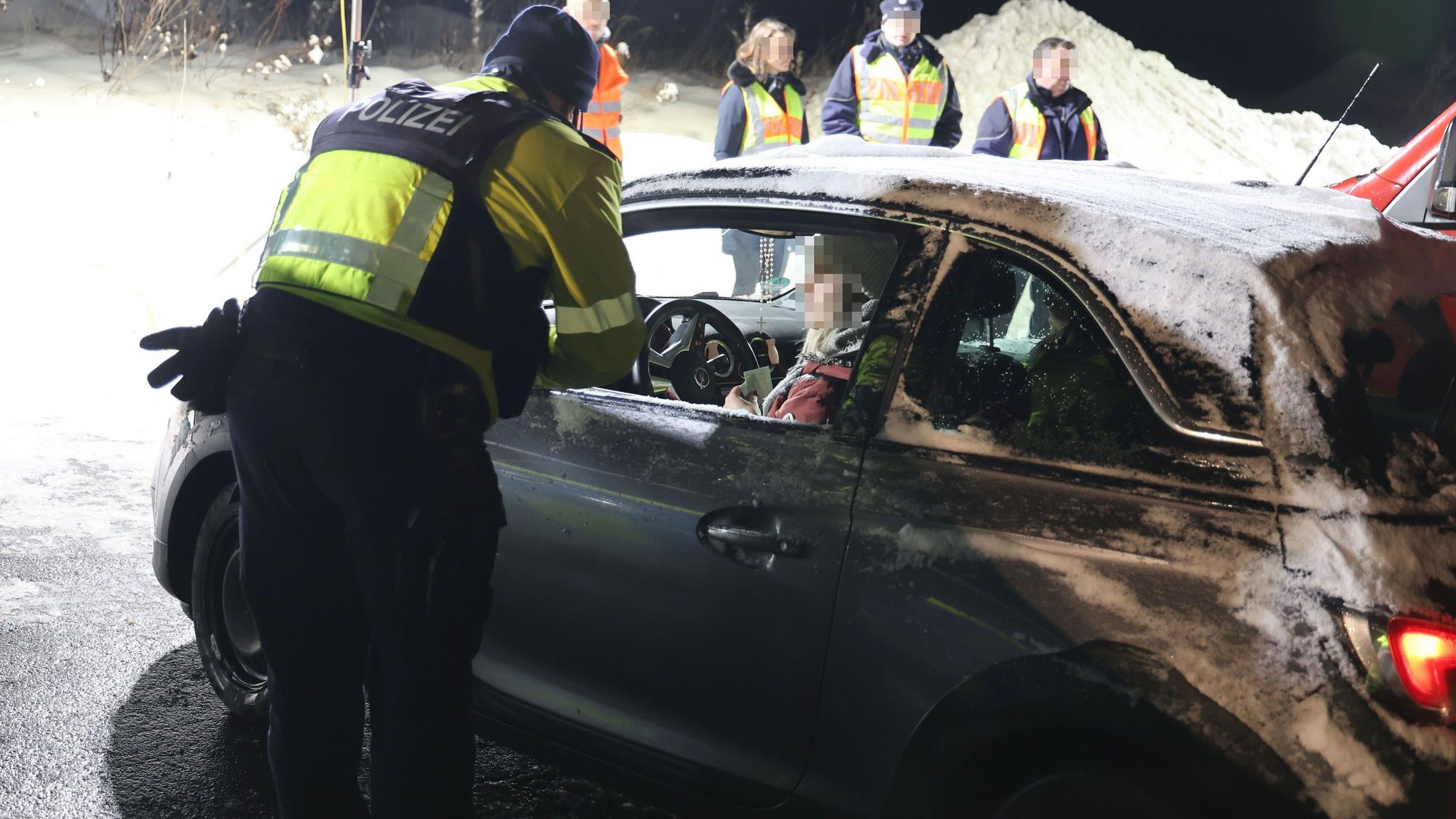 Ein Polizist überprüft eine Autofahrerin.