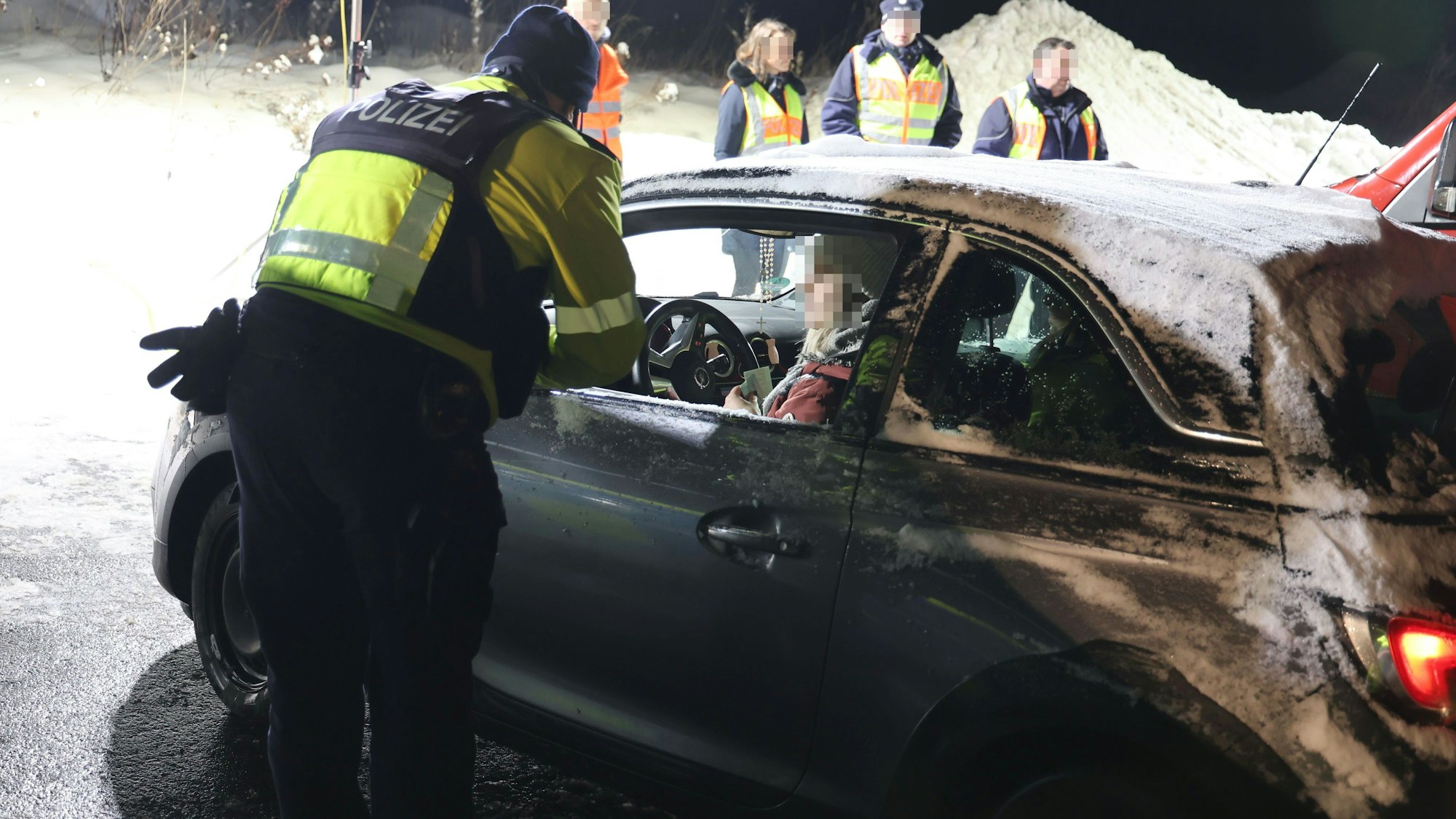 Ein Polizist überprüft eine Autofahrerin.
