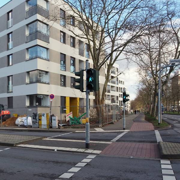 Neue Wohnblöcke, die zum Teil noch mit Bauzäunen abgesperrt sind, liegen direkt an einer großen Kreuzung.