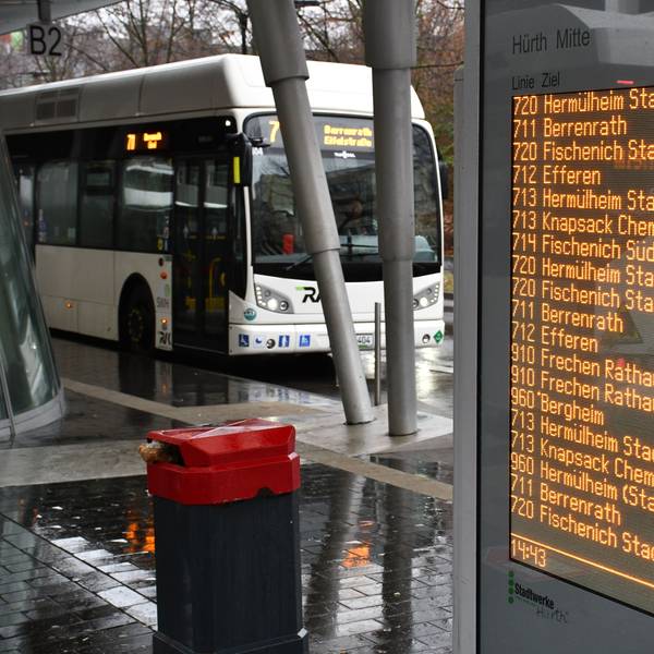 Eine digitale Anzeigetafel und ein Stadtbus am Busbahnhof in Hürth-Mitte.