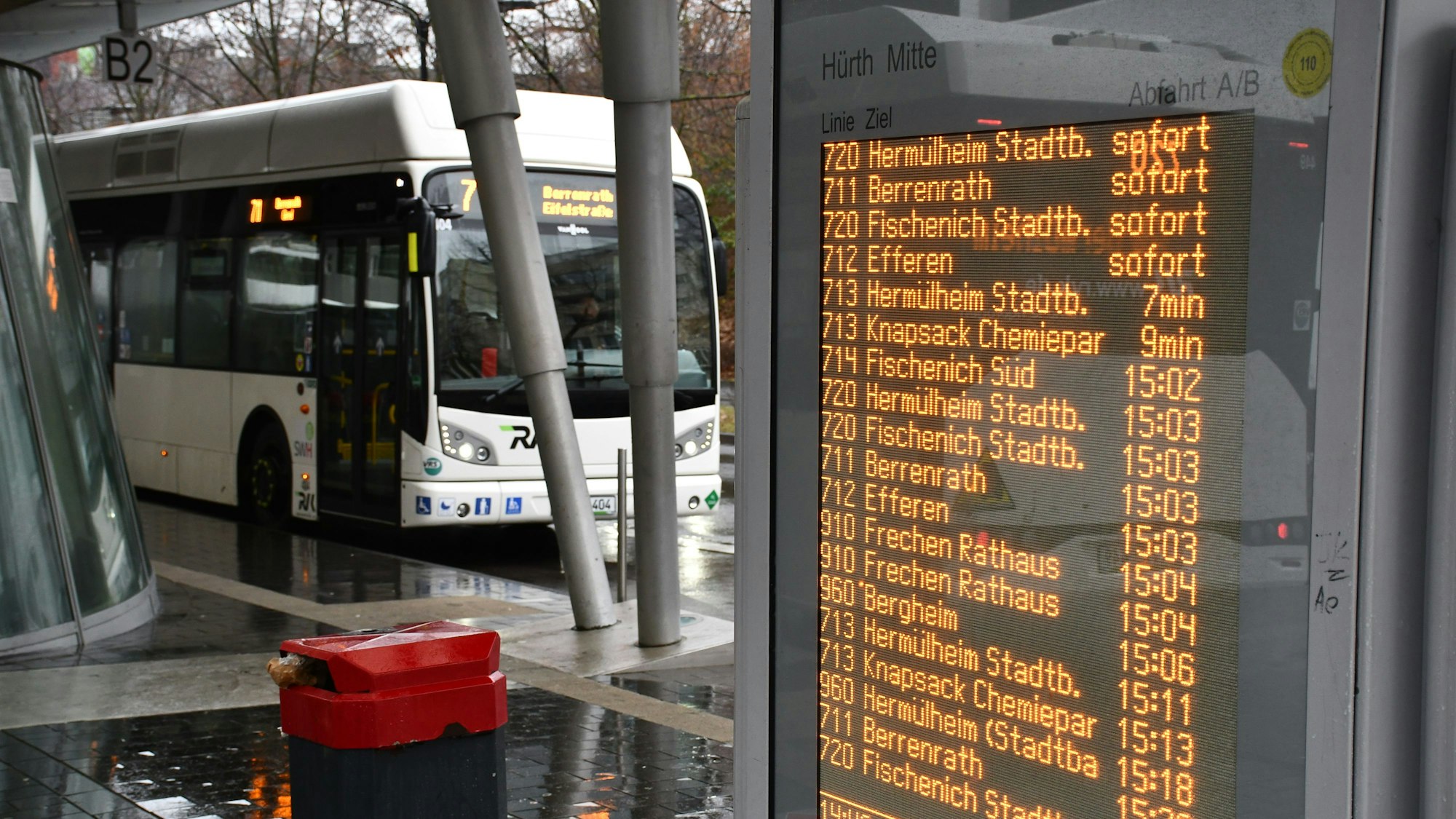 Eine digitale Anzeigetafel und ein Stadtbus am Busbahnhof in Hürth-Mitte.