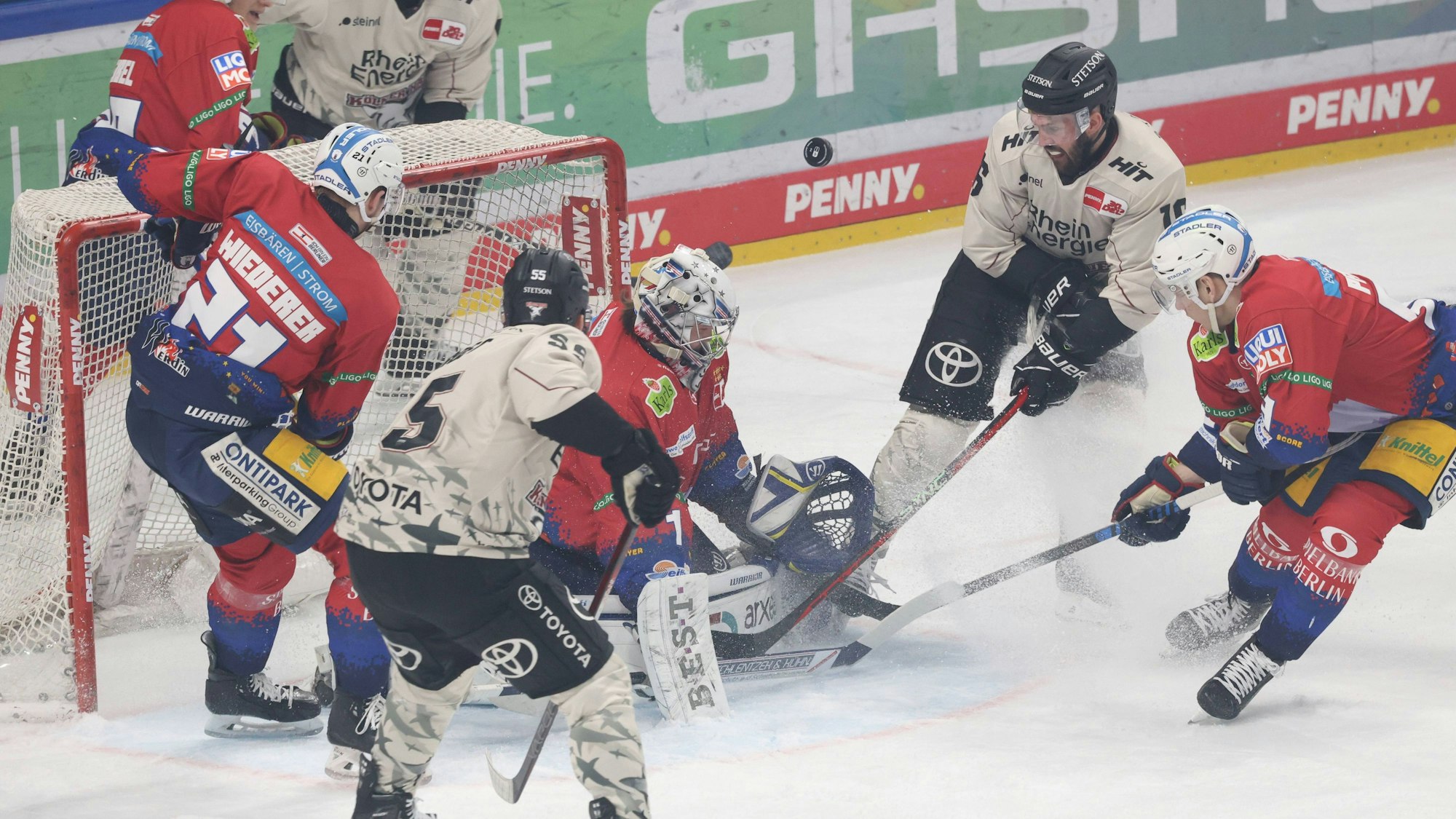 Die Kölner Haie belagern mit Jason Bast (r.) und Robin van Calster (l.) das von Jonas Stettmer gehütete Berliner Tor.