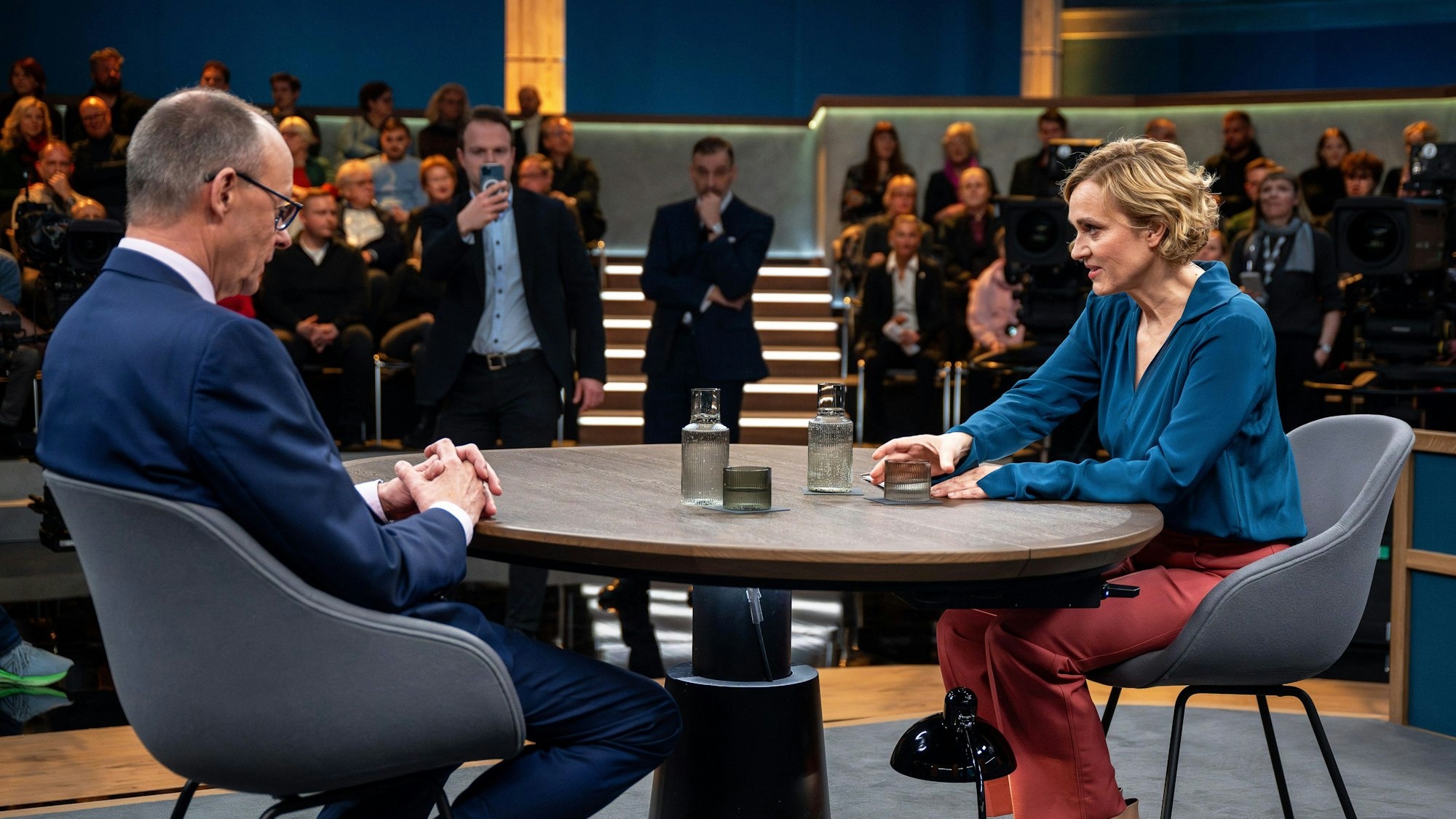 Caren Miosga (r.), Moderatorin, spricht vor Beginn der Sendung mit ihrem Gast Friedrich Merz.