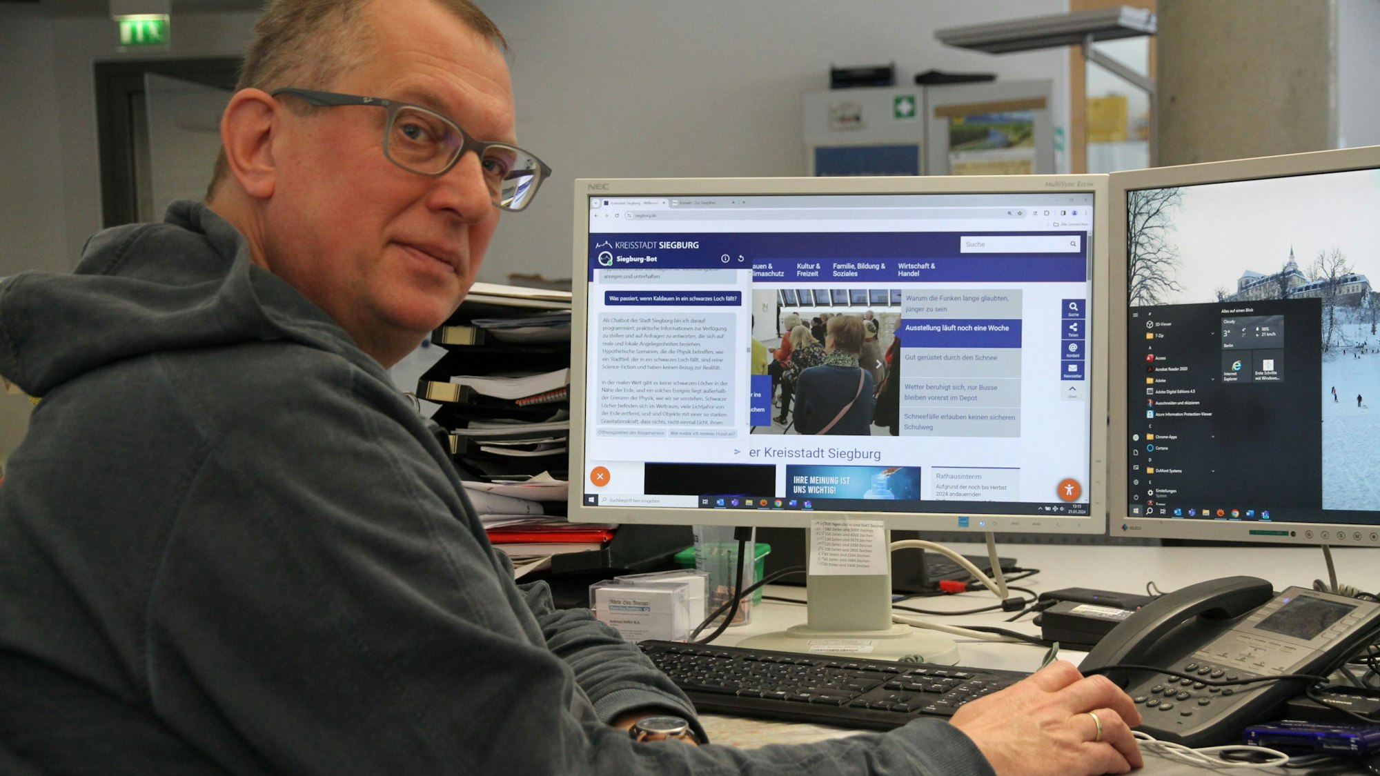 Ein Mann mit Brille an einem PC