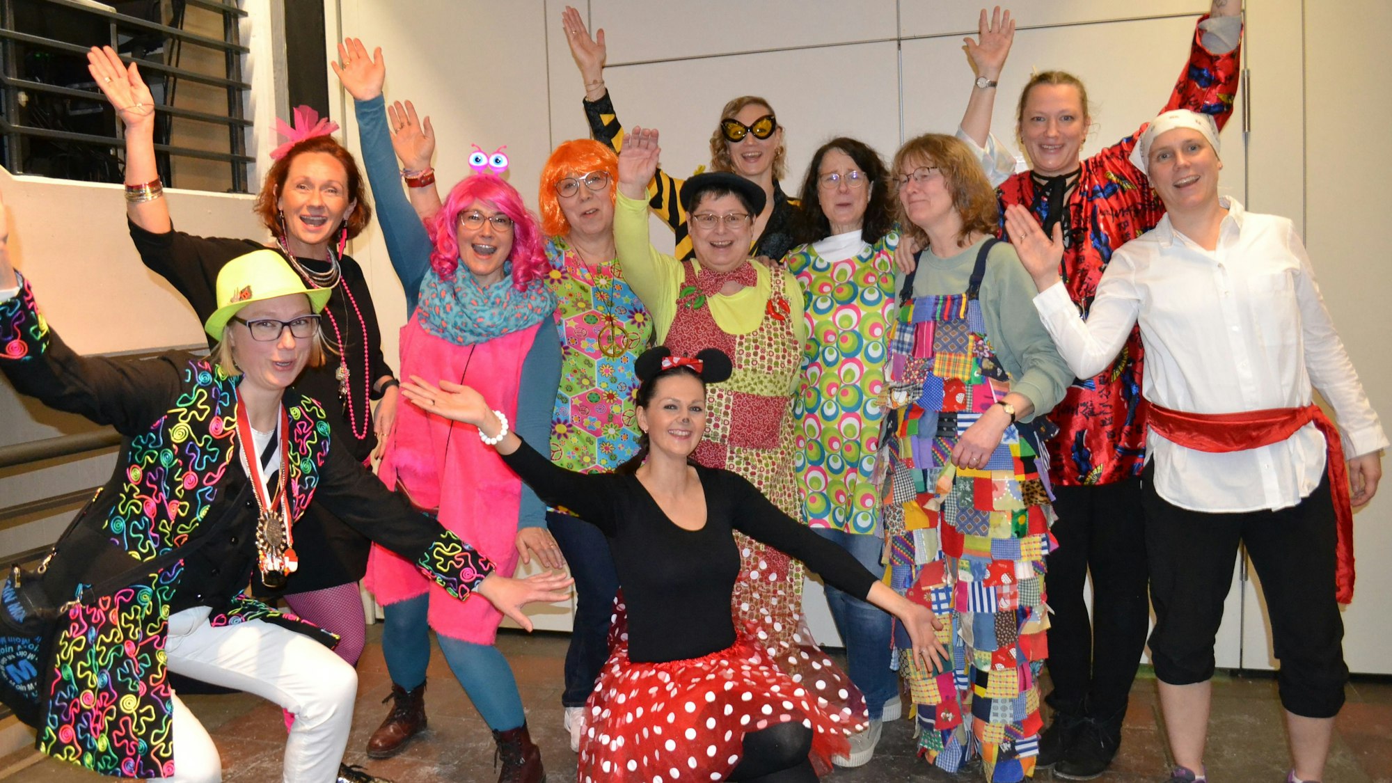 Bunt kostümierte Frauen lachen in die Kamera.
