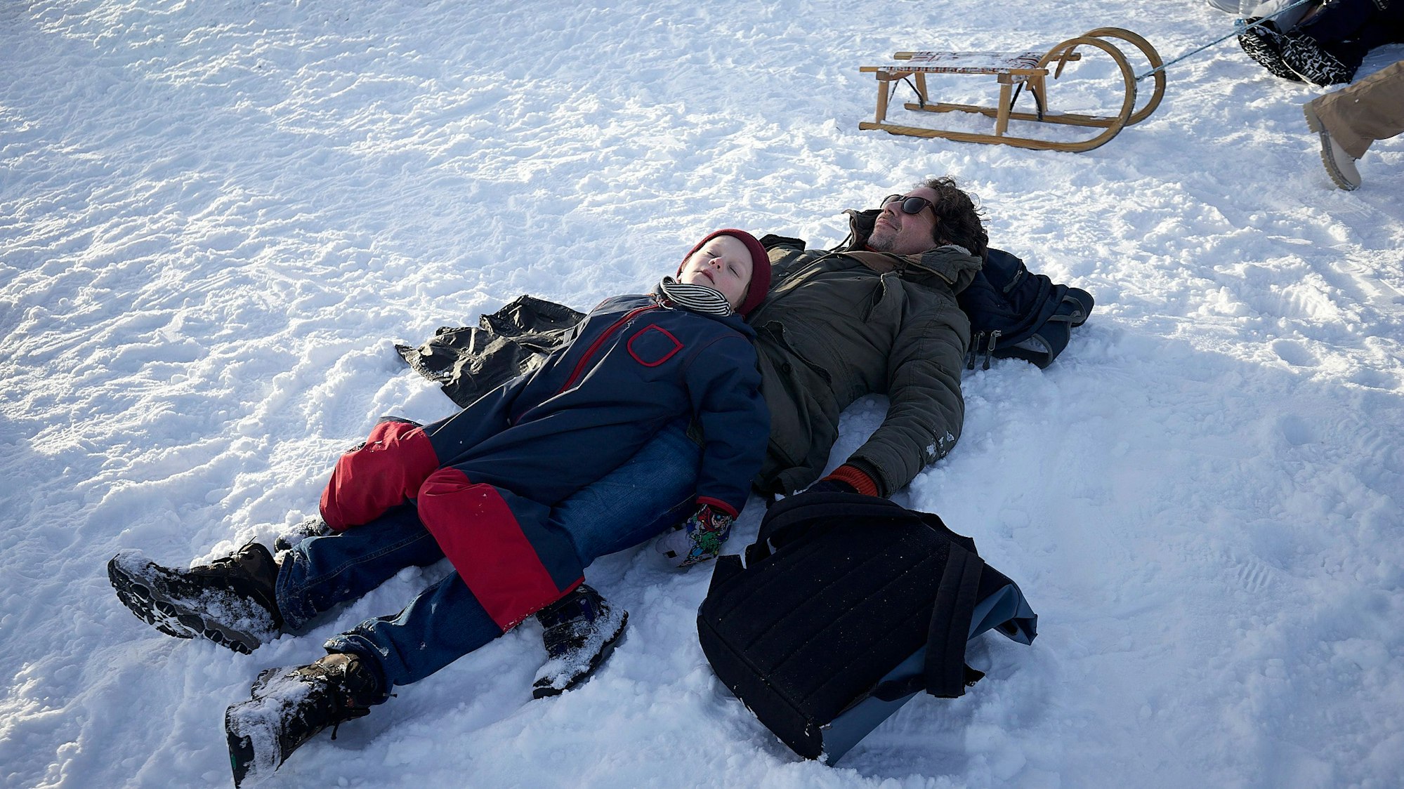Anton Weber liegt im Schnee, auf ihm Sohn Nils.