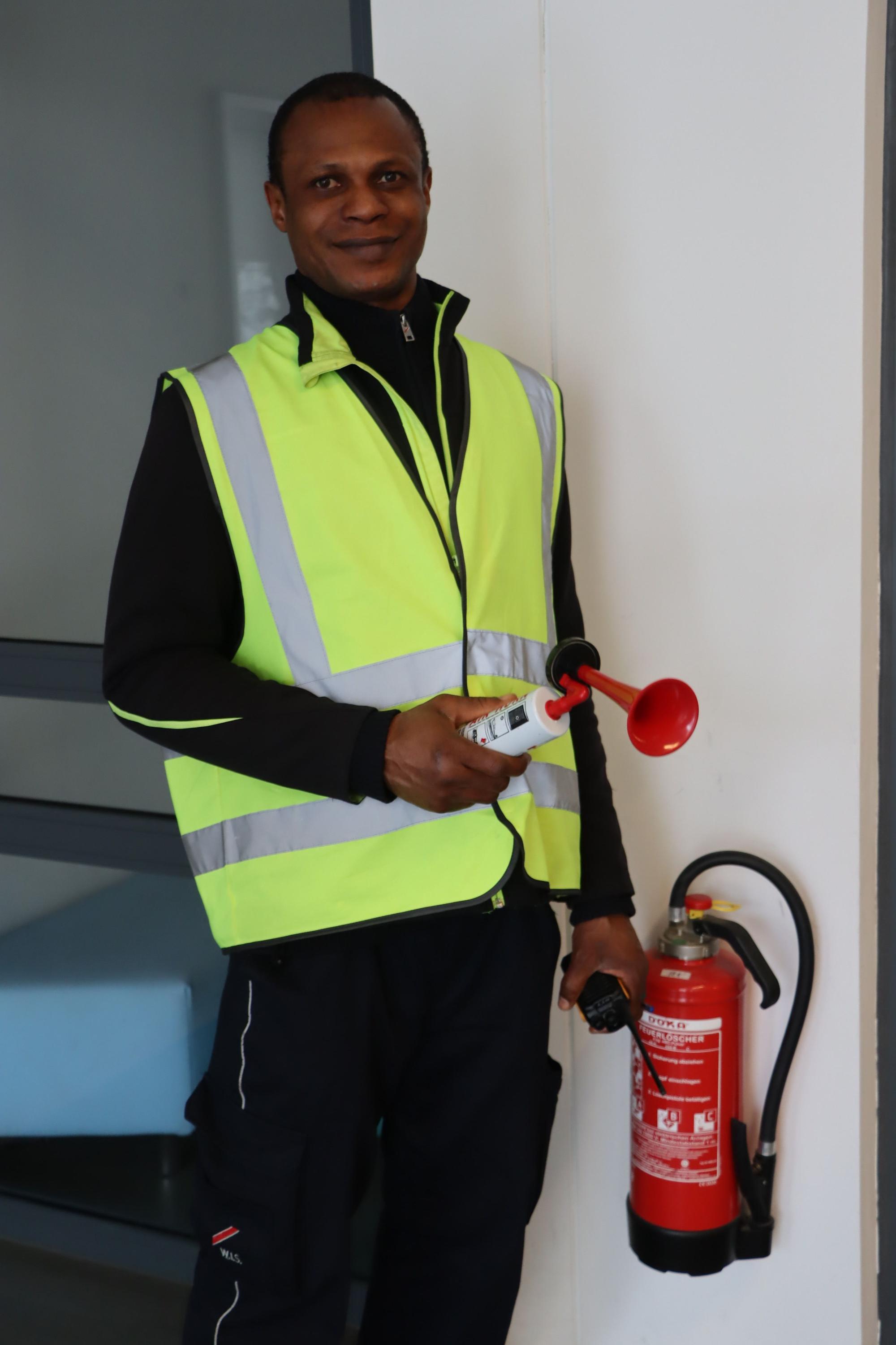 Die Pressluft-Alarm-Sirene hat Nnamdi Chosen vom Sicherheitsdienst direkt am Feuerlöscher jederzeit griffbereit.
