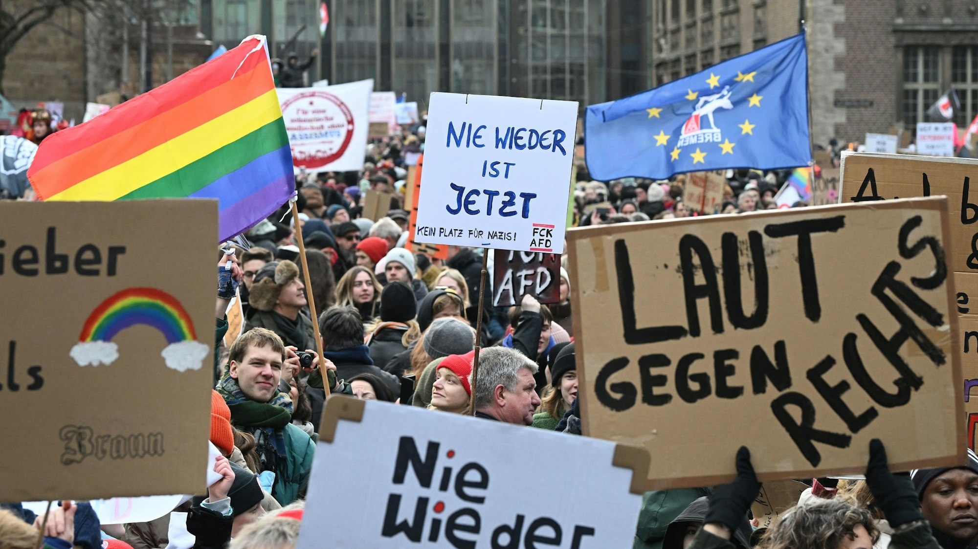 Mit selbstgemachten Schildern und Plakaten demonstrieren viele Menschen auf dem Marktplatz in Bremen gegen Rechtsextremismus.