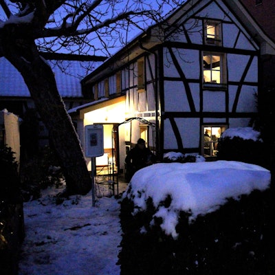 Ein erleuchtetes Fachwerkhäuschen am Abend im Schnee
