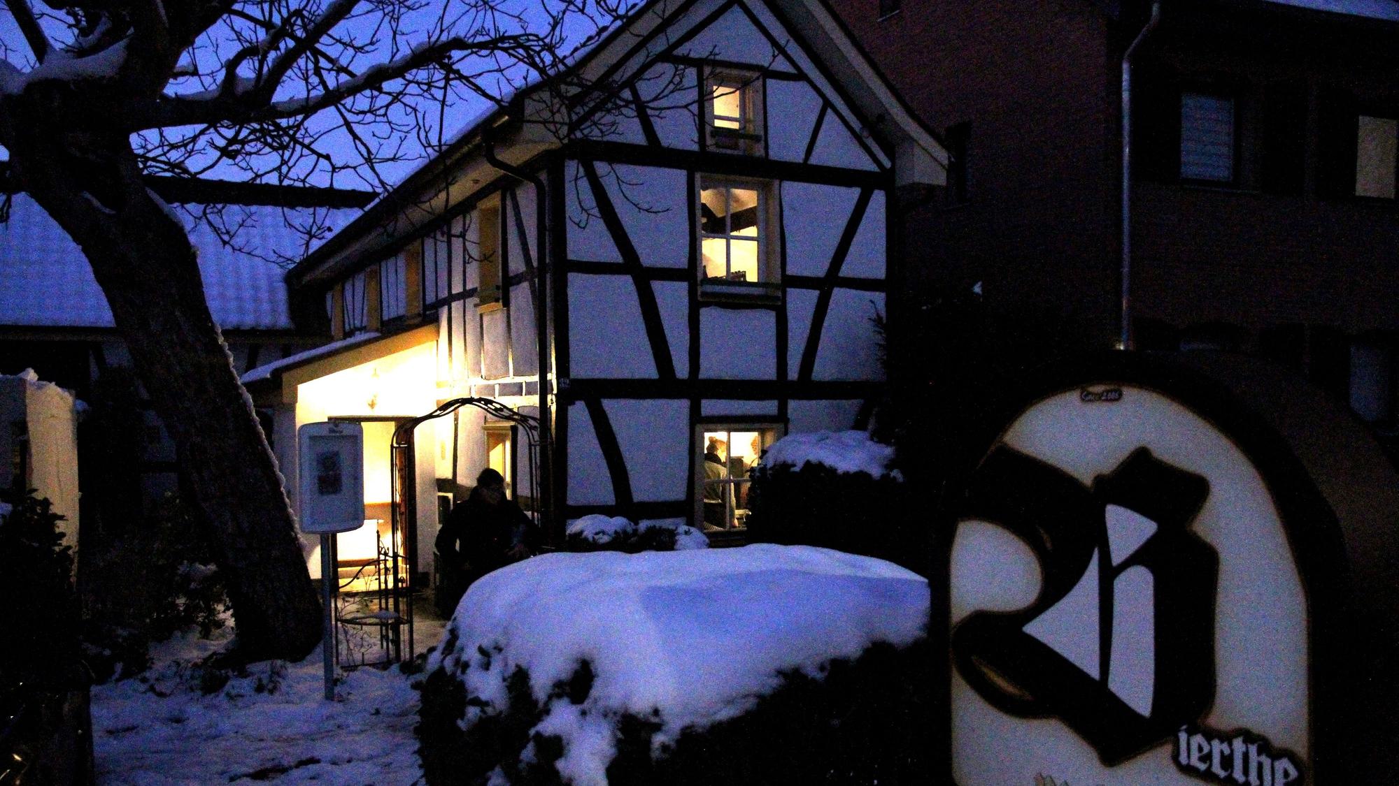 Ein erleuchtetes Fachwerkhäuschen am Abend im Schnee