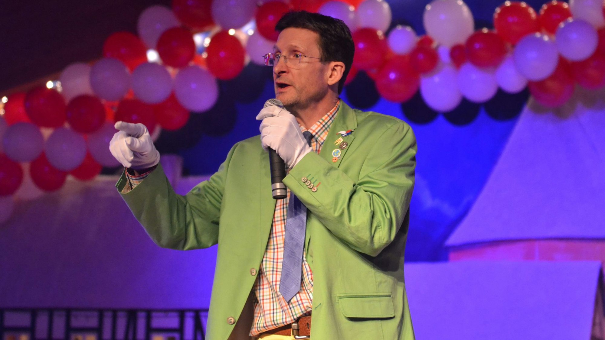 Edgar Andres als „Ne bonte Pitter“ steht in grünem Anzug auf der Bühne.