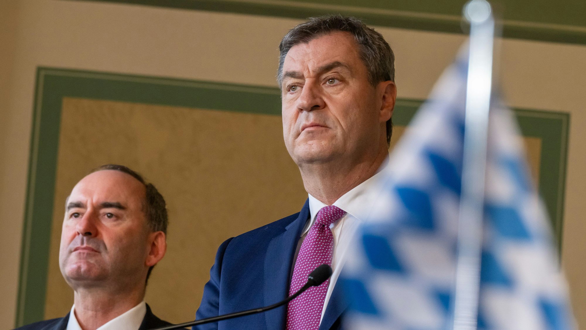 Hubert Aiwanger (l.) und Markus Söder (CSU) bei der Unterzeichnung vom Koalitionsvertrag von CSU und den Freien Wählern. Söder lobt die Demos gegen Rechts, Aiwanger kritisiert sie.