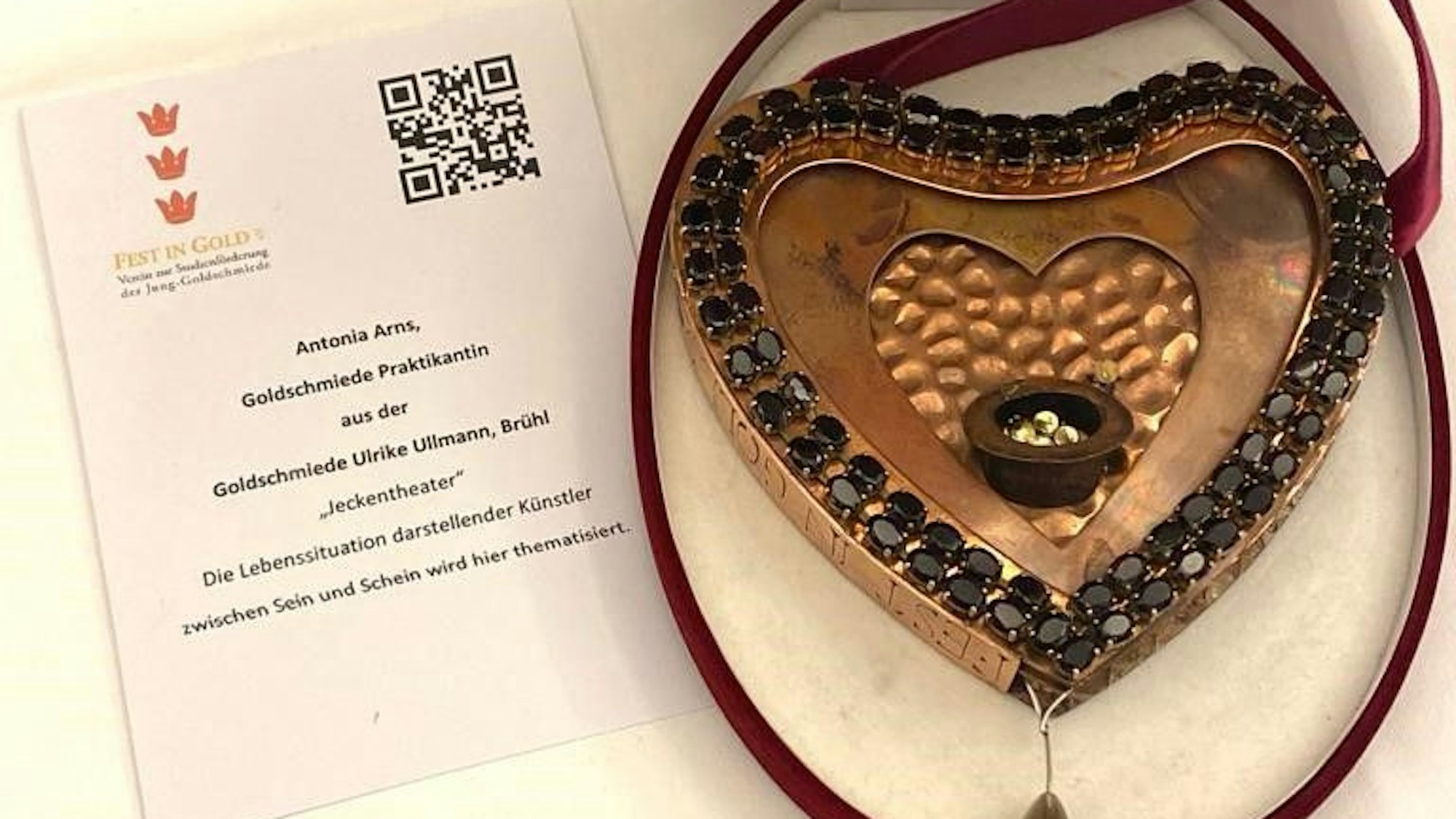Ein Orden in Herzform liegt in einer Schatulle.