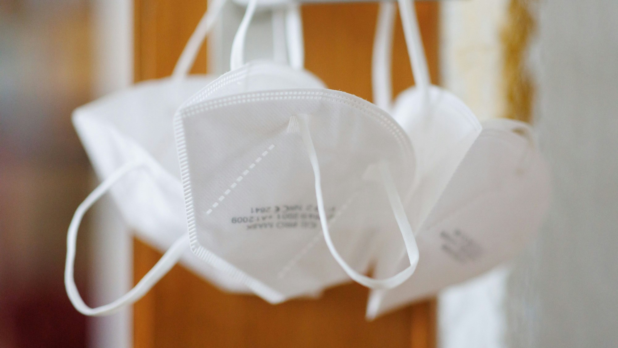 FFP2-Masken hängen an einer Türklinke.