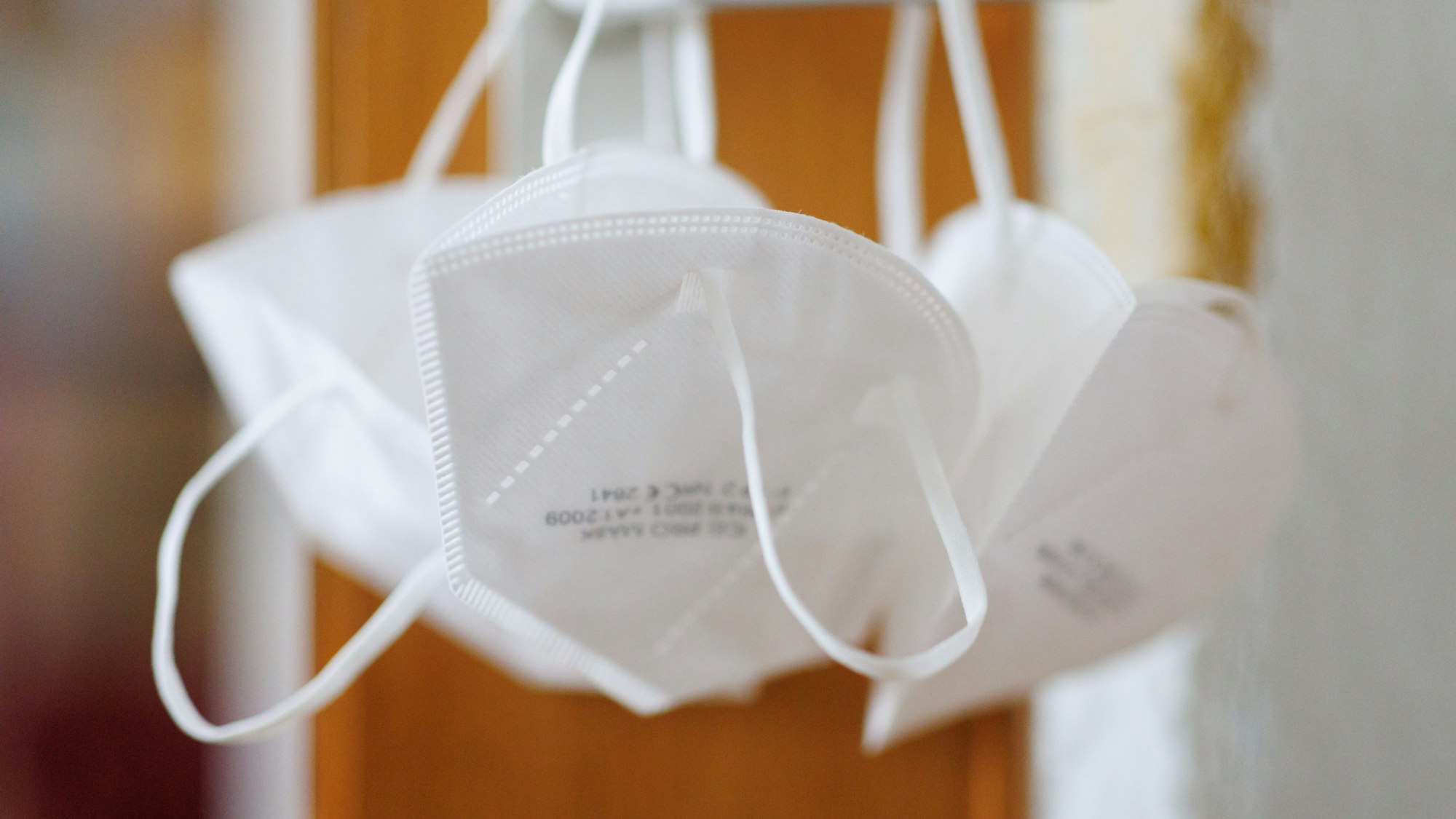 FFP2-Masken hängen an einer Türklinke.