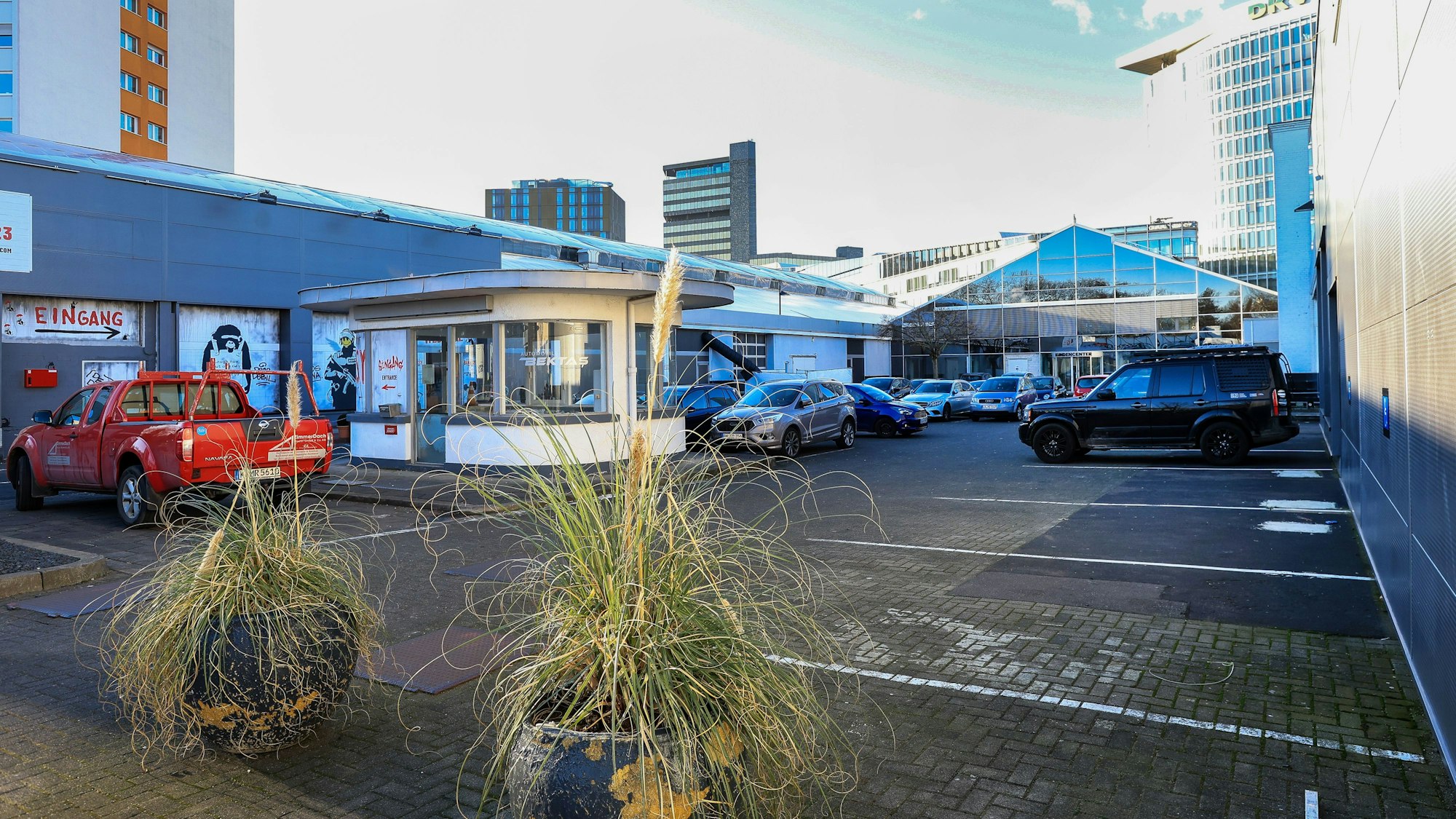 Blick auf ein langgestrecktes Flachdach-Gebäude, das derzeit mit Plakaten für die Banksy-Ausstellung beklebt ist