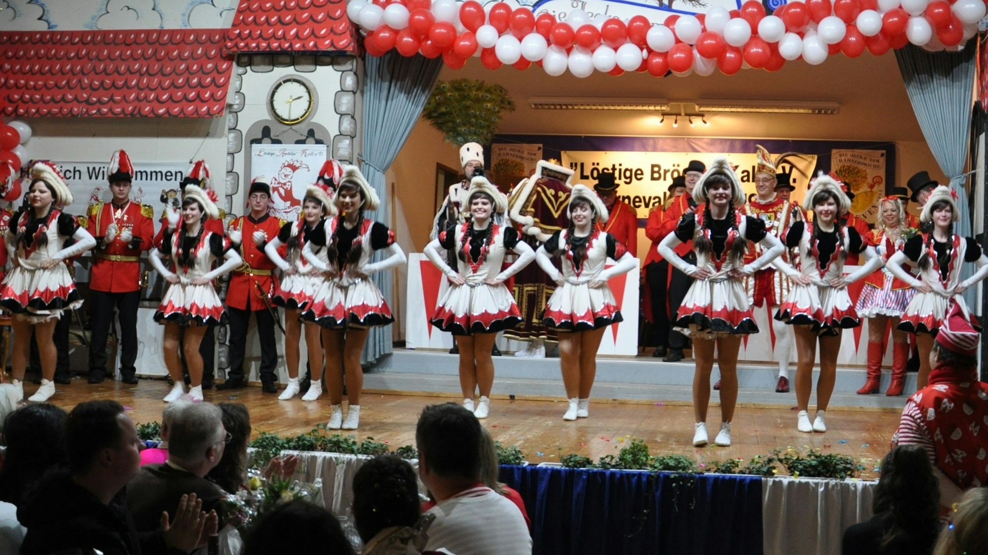 Die Tänzerinnen der Kallbachmücken stehen in ihren Kostümen auf einer Karnevalsbühne.