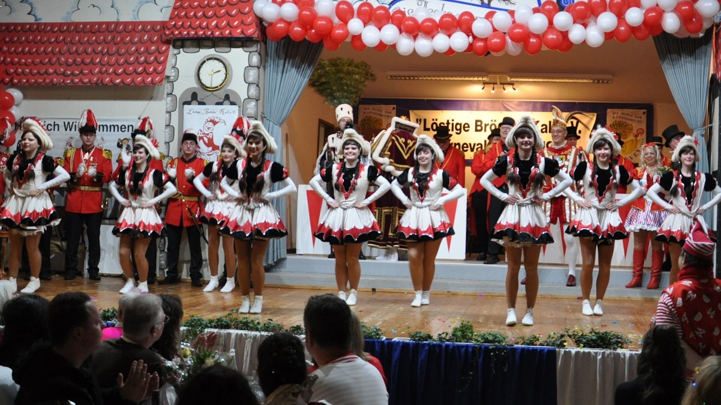 Die Tänzerinnen der Kallbachmücken stehen in ihren Kostümen auf einer Karnevalsbühne.