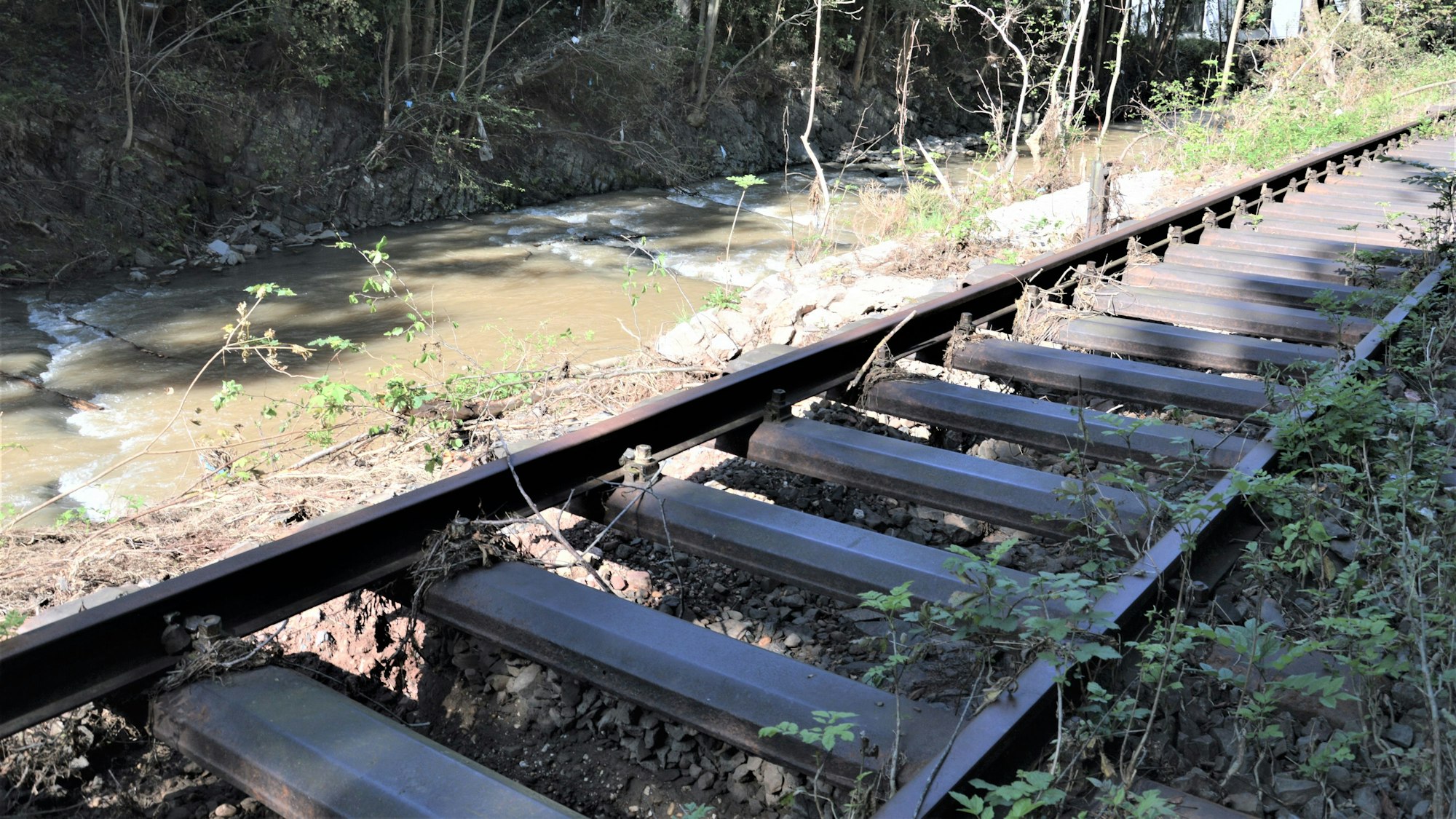 Das Bild zeigt Gleise, deren Bett weggespült wurde.