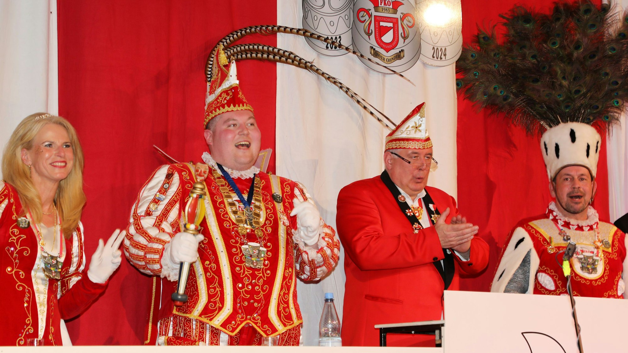 Ein Dreigestirn und ein Sitzungsleiter tanzen am Elferratstisch.