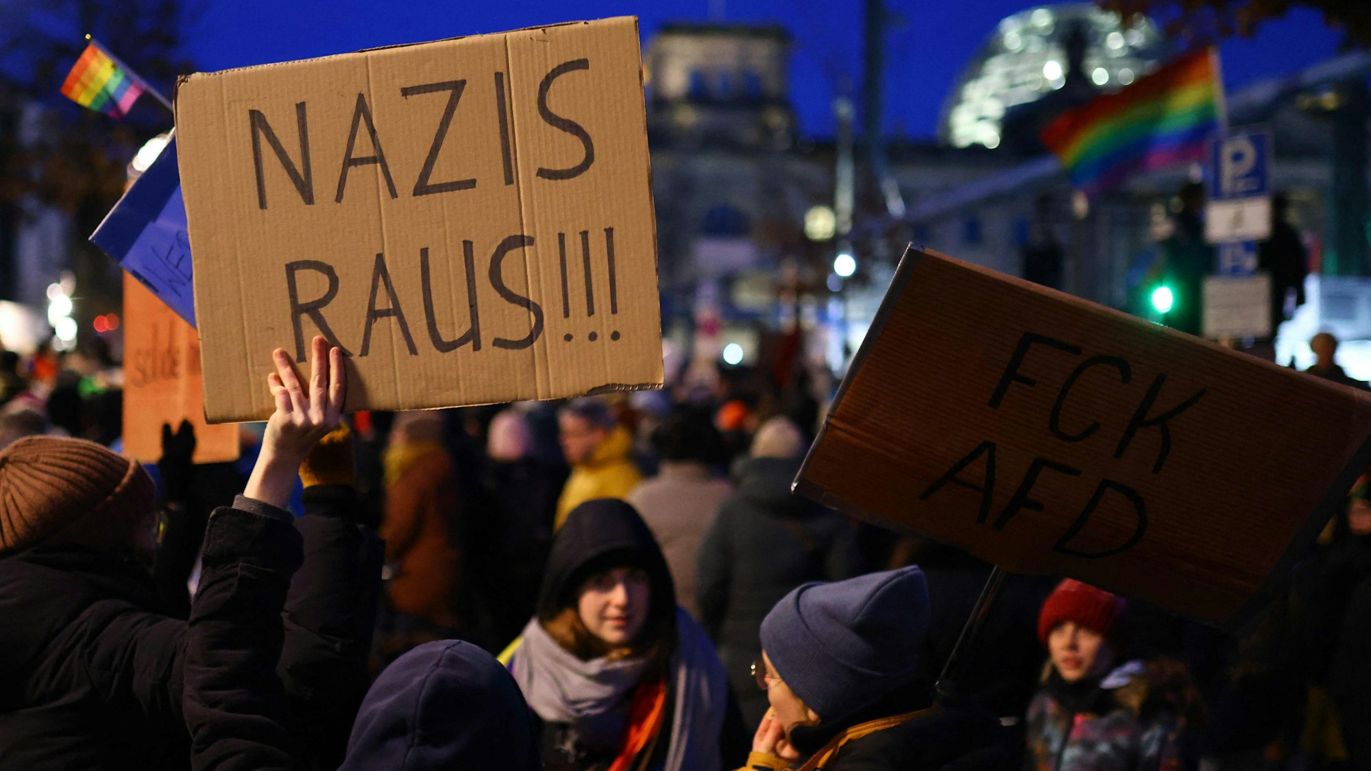 Ein Teilnehmer hält ein Plakat mit der Aufschrift „Nazis raus“ während einer Demonstration gegen Rassismus und rechtsextreme Politik hoch (Symbolbild). Wegen eines Plakates in Aachen ermittelt nun die Polizei.