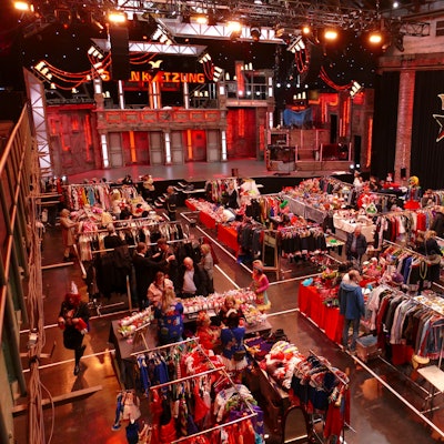 Ein Flohmarkt mit Kostümen in einer Veranstaltungshalle.