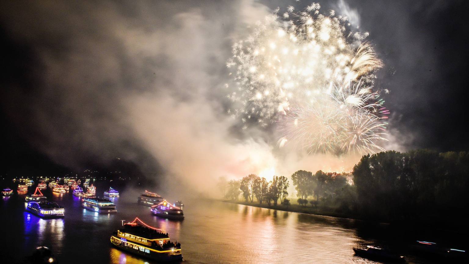 Bunt beleuchtete Boote und Schiffe sowie ein Feuerwerk sind in Bonn beim Fest „Rhein in Flammen“ zu sehen.