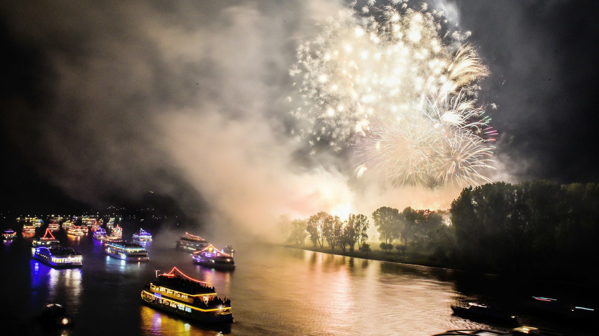 Bunt beleuchtete Boote und Schiffe sowie ein Feuerwerk sind in Bonn beim Fest „Rhein in Flammen“ zu sehen.