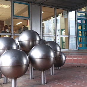 Eine Skulptur mit Kugeln vor dem Eingang zum Hürther Rathaus.