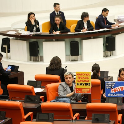 Nicht alle sind dafür: Linke Abgeordnete halten in der Debatte im türkischen Parlament Plakate mit der Aufschrift „Keine Besatzung, kein Krieg für die Nato“ hoch.