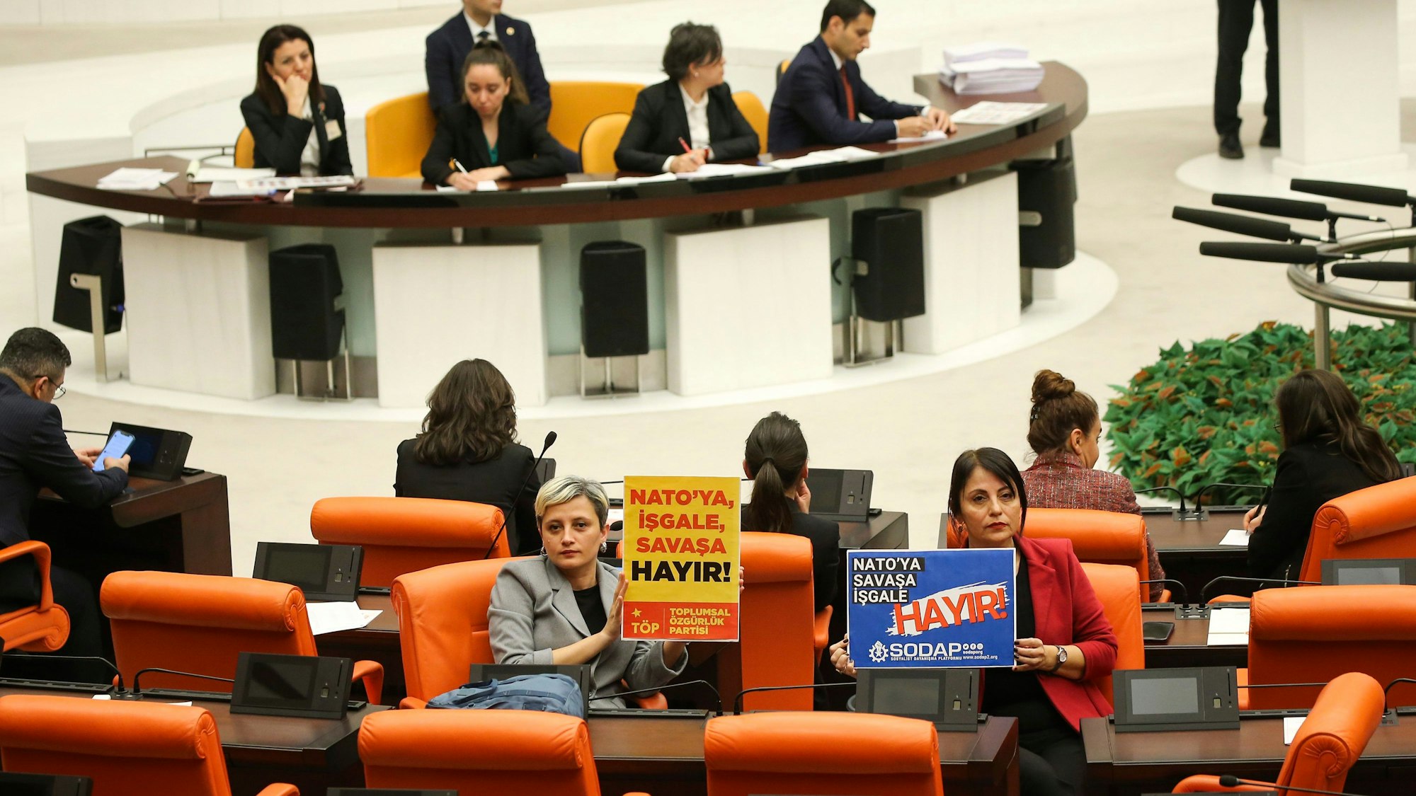 Nicht alle sind dafür: Linke Abgeordnete halten in der Debatte im türkischen Parlament Plakate mit der Aufschrift „Keine Besatzung, kein Krieg für die Nato“ hoch.