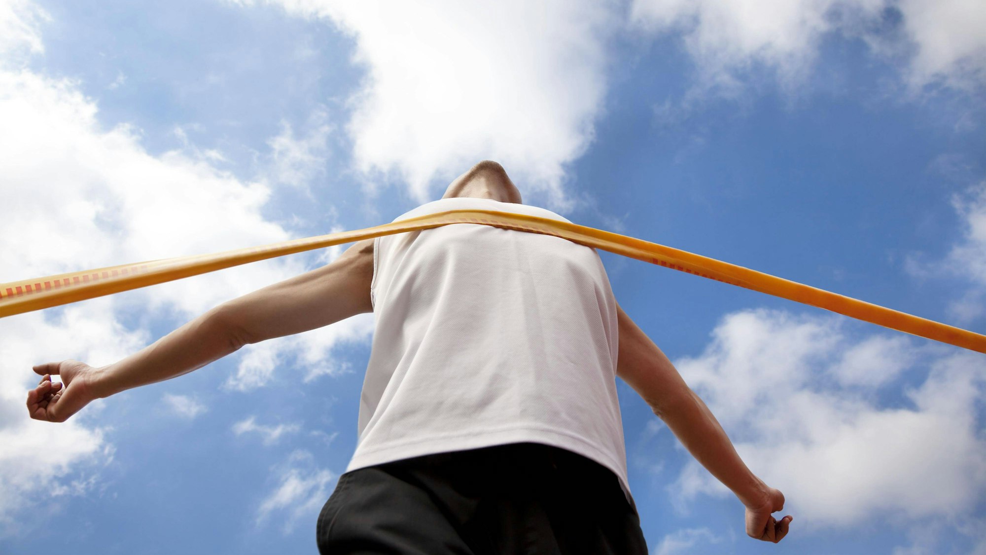 Ein Sportler erreicht das Zielband.