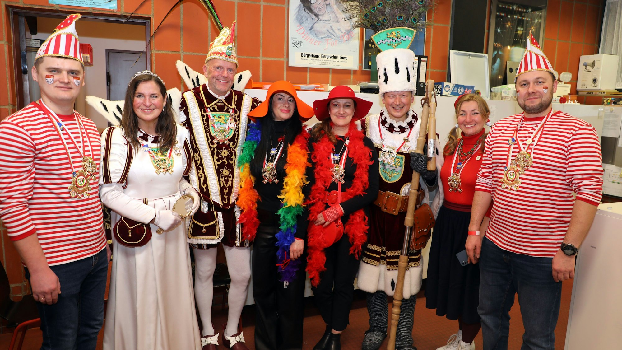 Bund Kostümierte stehen mit einem Dreigestirn im Hausmeisterraum des Bürgerhauses Bergischer Löwe.