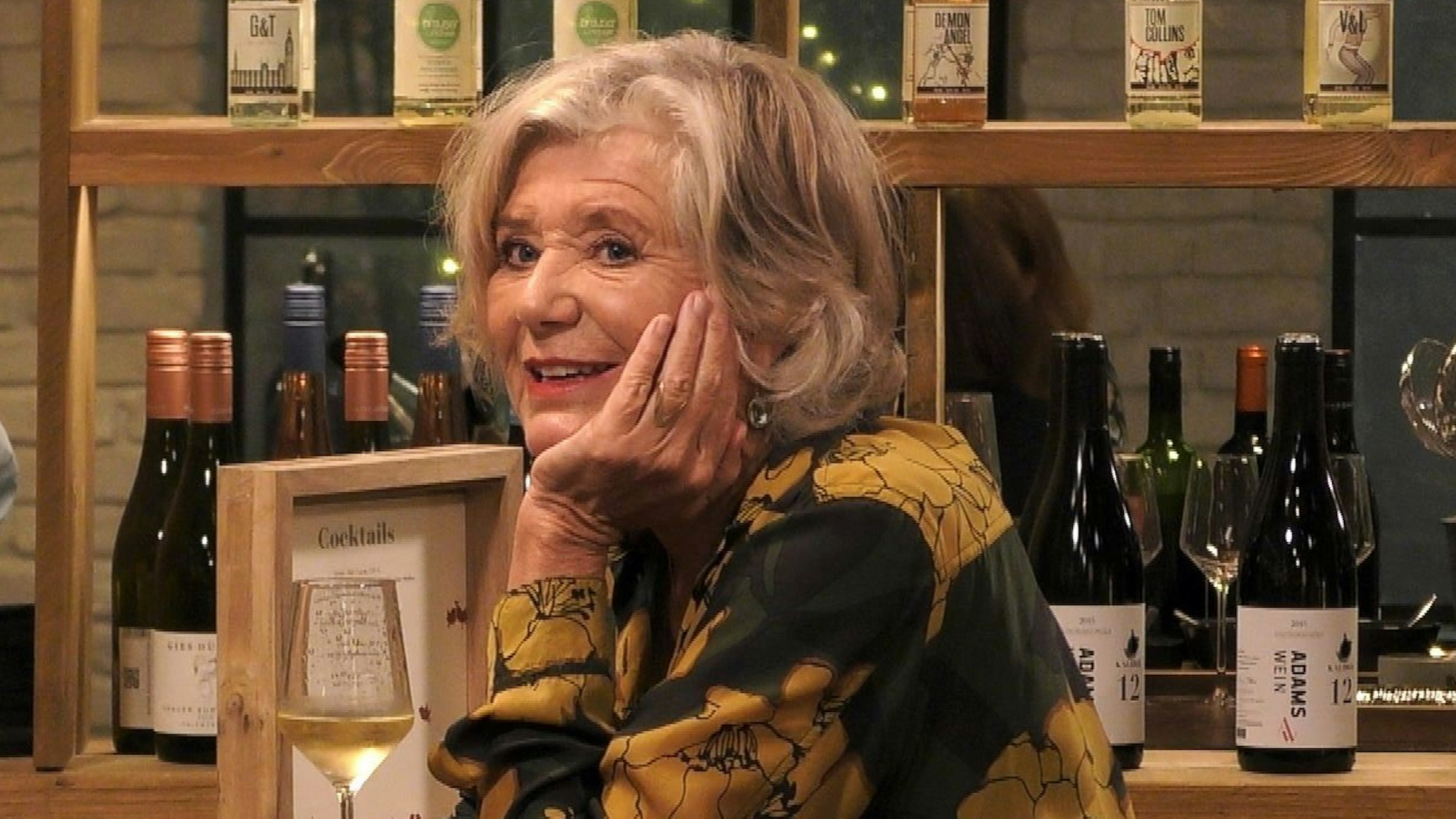 Jutta Speidel sitzt an einer Theke – Gast bei „Promi First Dates“.