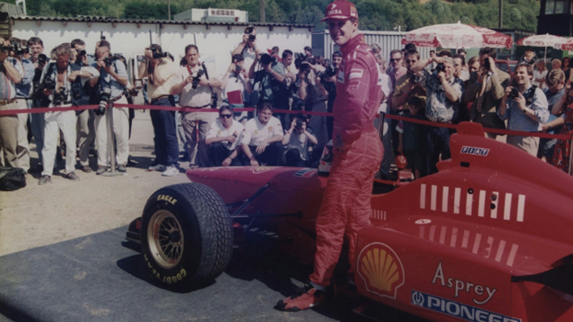 Auf dem Foto ist Michael Schumacher vor seinem roten Ferrari bei einem Termin 1996 in Kerpen zu sehen.