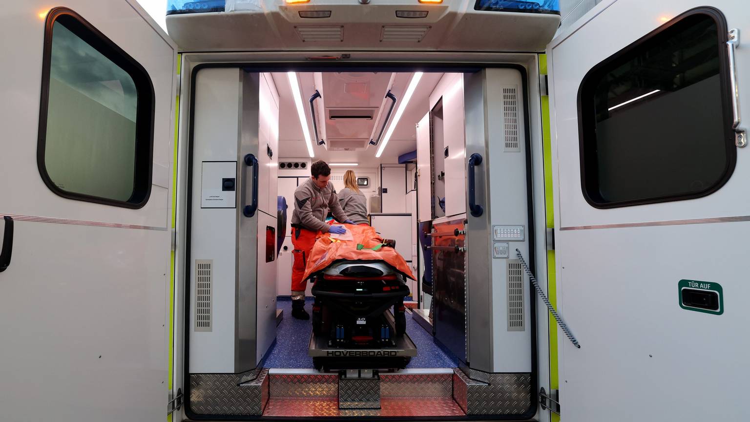 Blick in einen Rettungswagen, darin stehen zwei Notfallsanitäter.