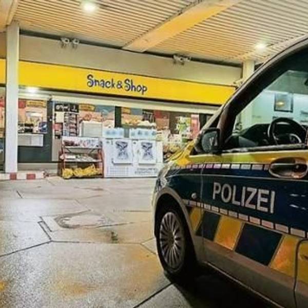Ein Polizeiauto steht an einer Tankstelle.