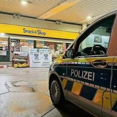 Ein Polizeiauto steht an einer Tankstelle.