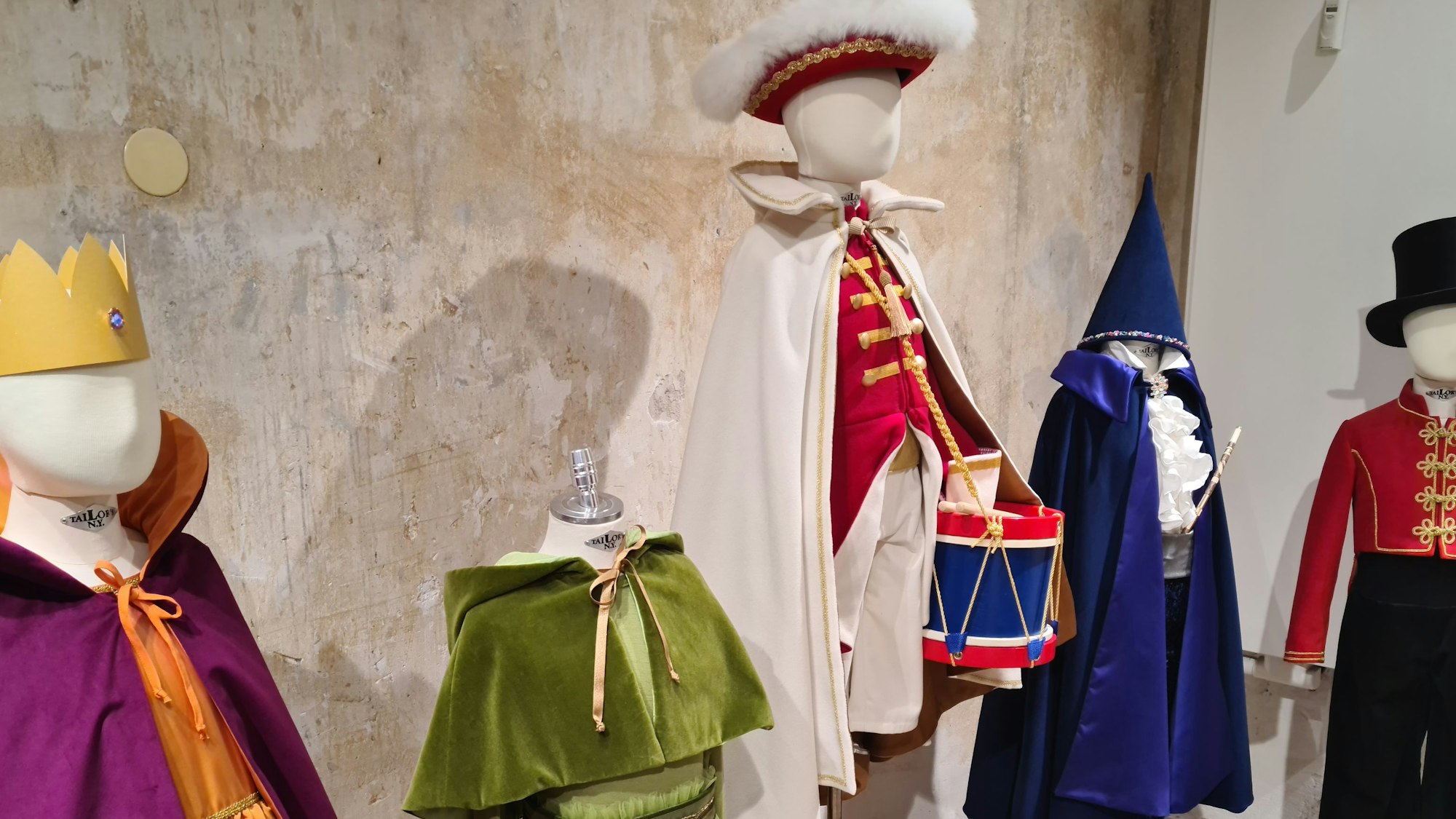Auf Puppen drapiert sind Kostüme für Jungs und Mädchen.
