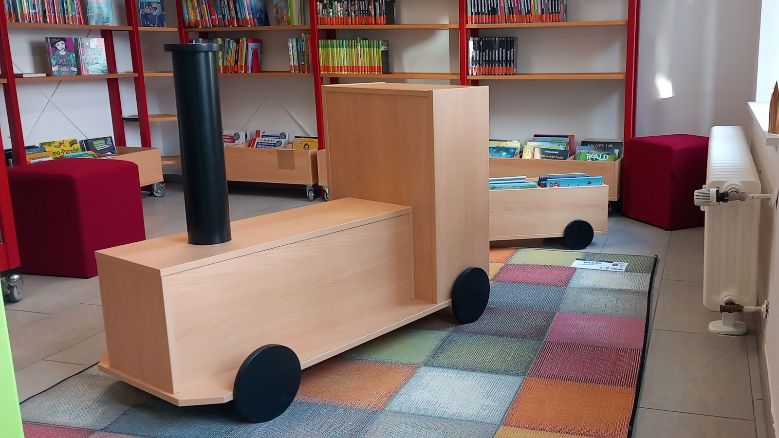 Die Holzeisenbahn ist gleichzeitig Bücherregal und Sitzmöbel