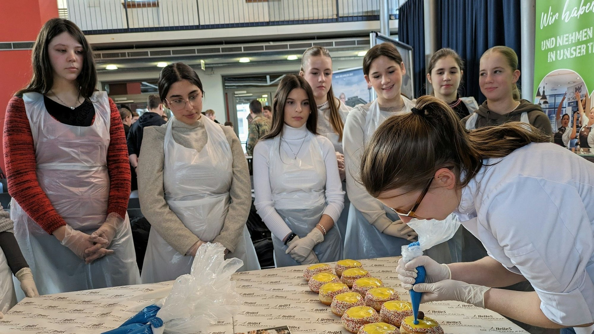 Beim Aktionstag „Berufe live“ an der Heinrich-Böll-Gesamtschule zeigte Konditormeisterin Melanie Büchsler von der Backmanufaktur Nelles, wie sie Berliner bunt verziert.