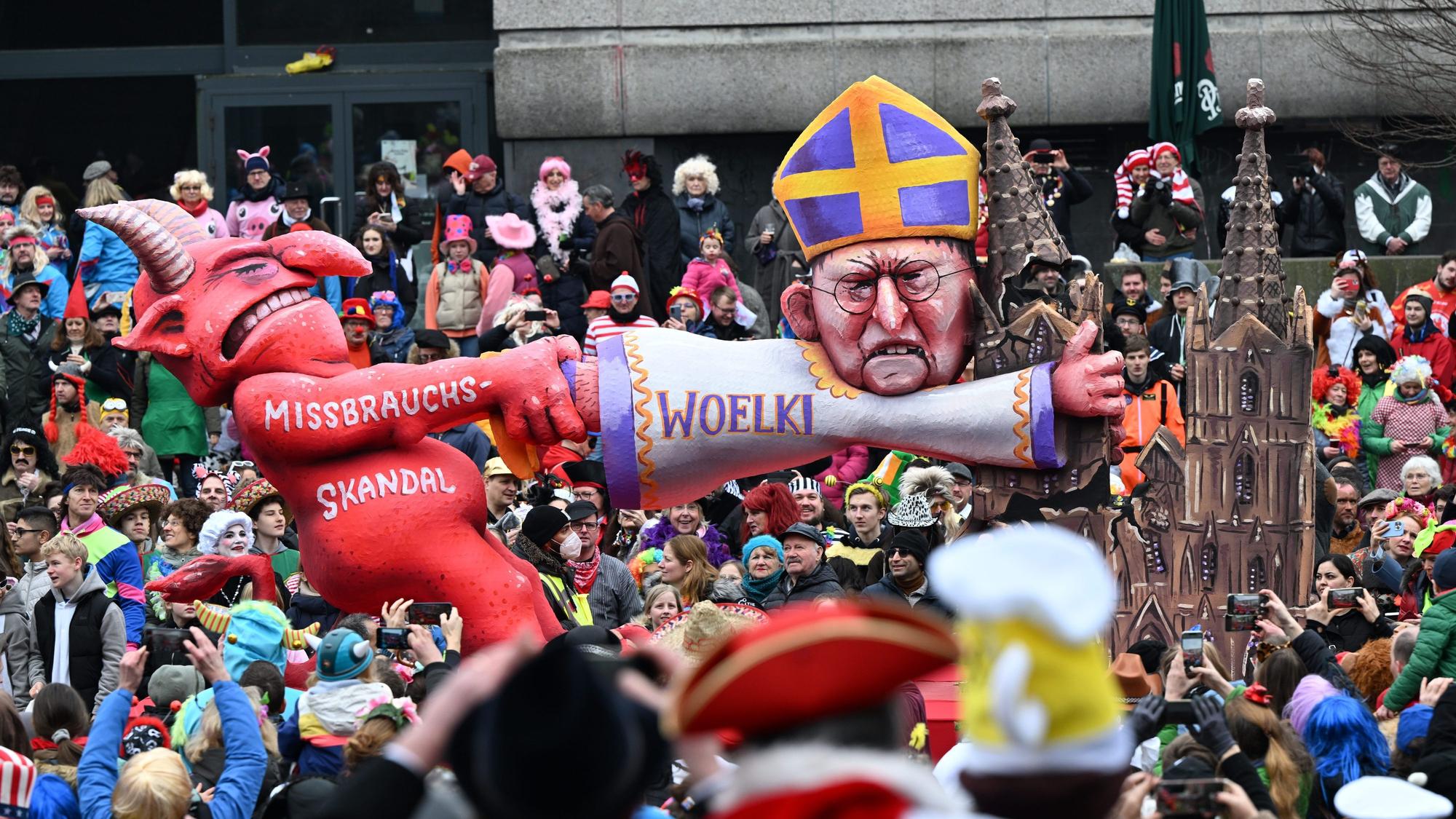 20.02.2023, Nordrhein-Westfalen, Düsseldorf: Ein Mottowagen befasst sich mit dem Missbrauchsskandal in der katholischen Kirche und zeigt den Teufel und den Kölner Kardinal Woelki. I