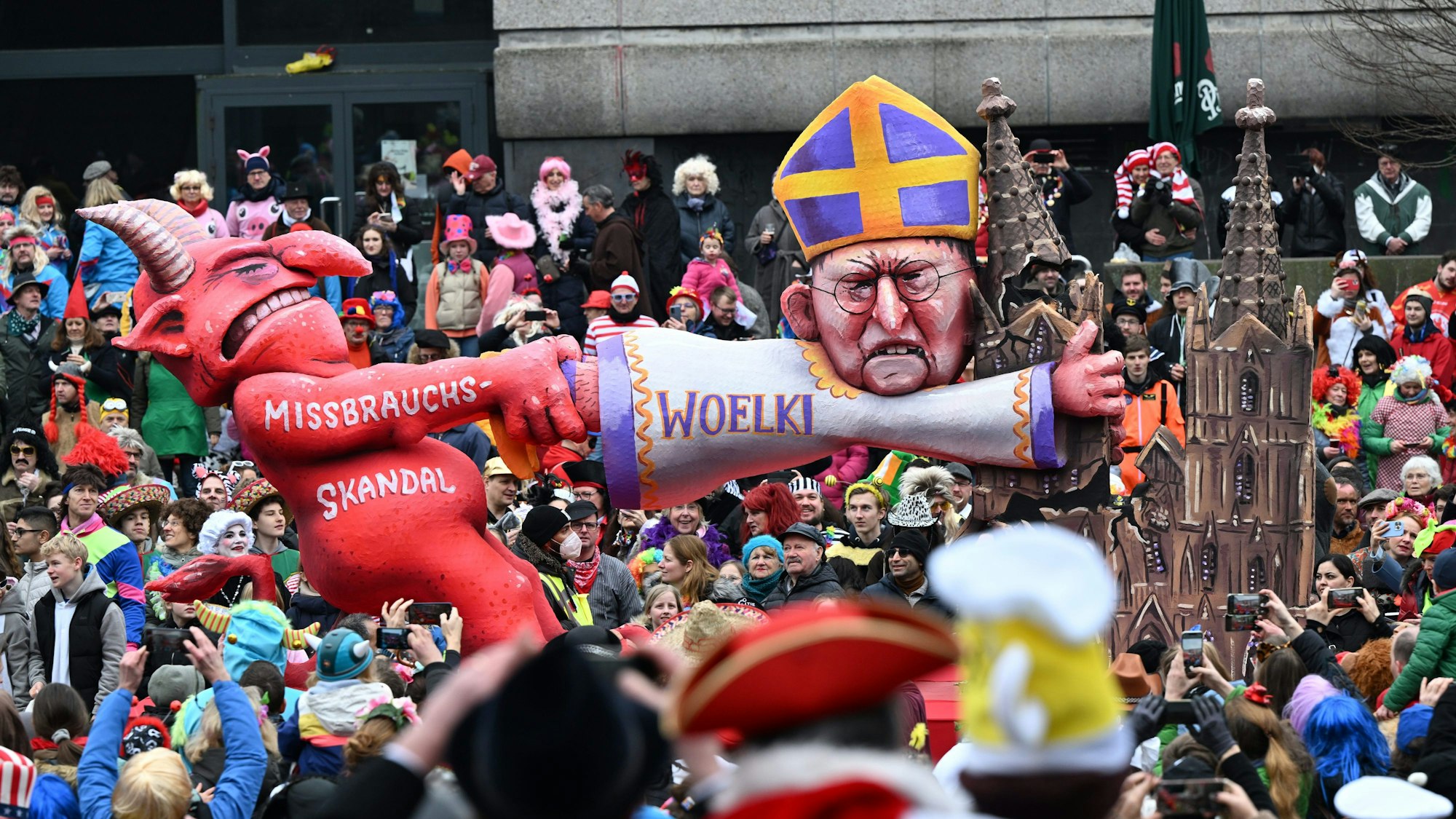 20.02.2023, Nordrhein-Westfalen, Düsseldorf: Ein Mottowagen befasst sich mit dem Missbrauchsskandal in der katholischen Kirche und zeigt den Teufel und den Kölner Kardinal Woelki. I