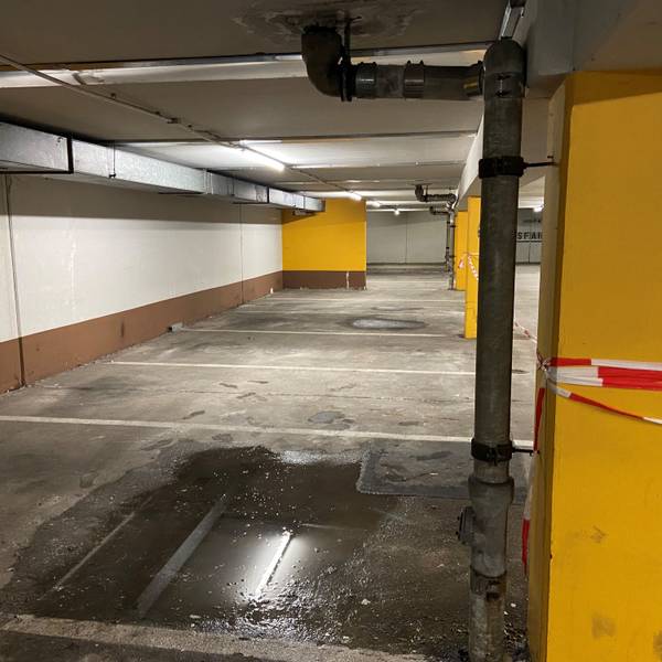Auf dem Bild ist eine Pfütze in der Tiefgarage zu sehen.