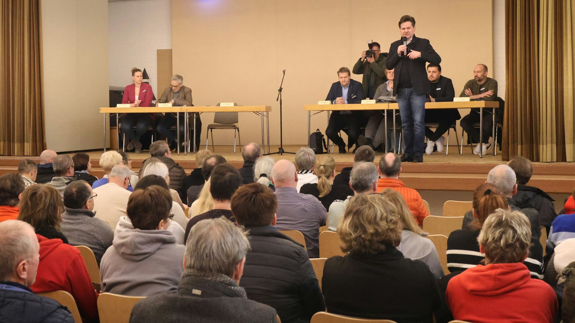 Ein Mann spricht vor einer größeren Menge.