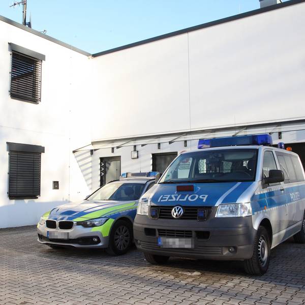 Zwei Einsatzfahrzeuge parken vor der Polizeiwache in Untereschbach.