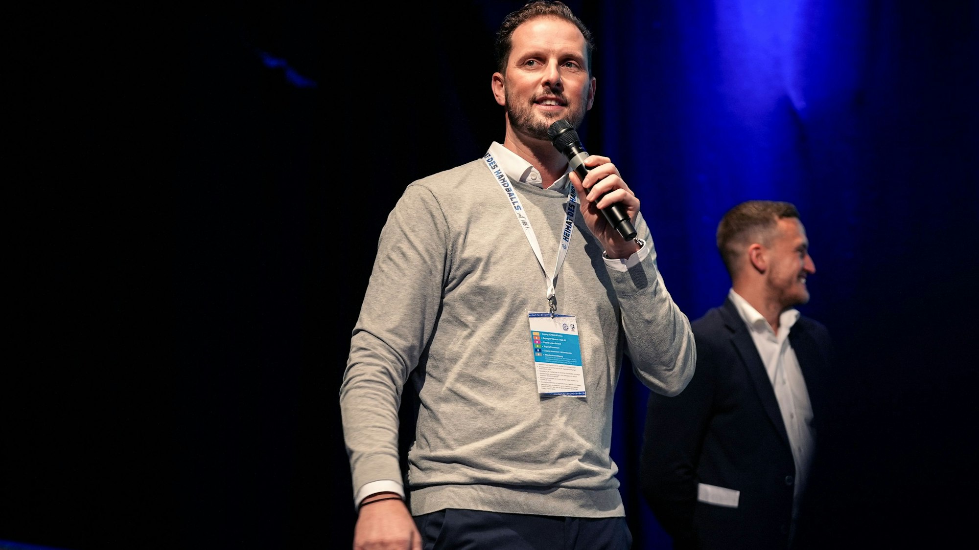 Christoph Schindler, Geschäftsführer VfL Gummersbach, mit Mikrophon auf der Bühne.